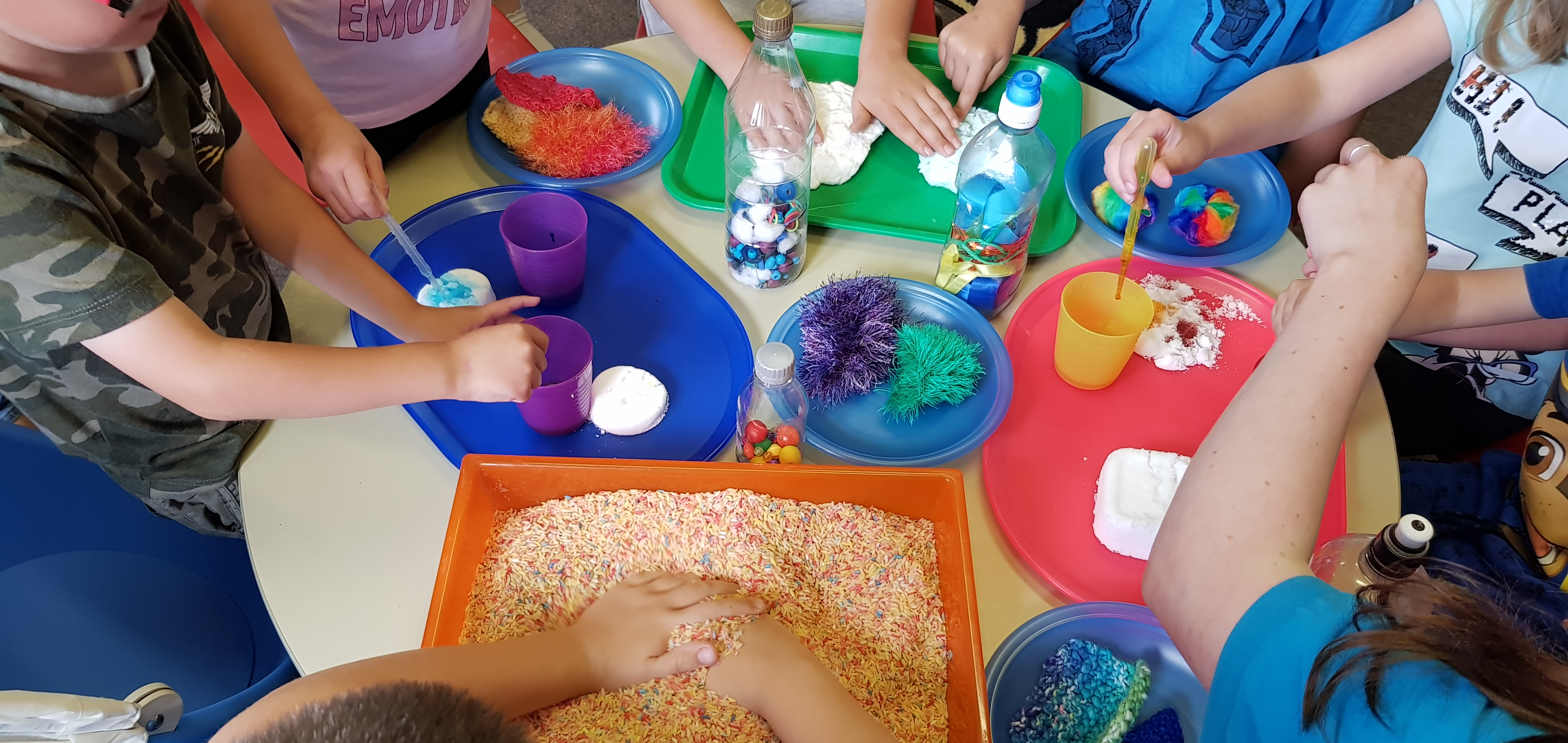 Hands of children touching different sensory items