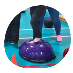 a child's feet balancing on a dome shaped BOSU ball