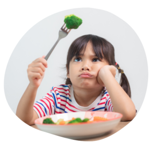 Child holding a fork with green vegetable on it, looking disgruntled